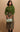 petite woman in green cardigan and olive green suede midi skirt