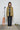Person wearing a yellow plaid shirt with a microphone and roller skates in the background