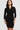 Woman wearing a black wrap dress against a white background