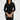Woman wearing a black dress holding a clutch against a plain background