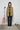 Person wearing a yellow plaid shirt with a microphone and roller skates in the background